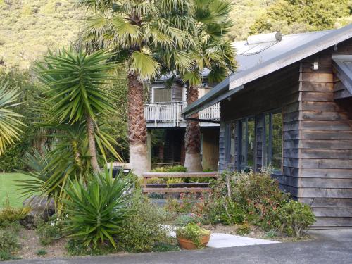 a house with palm trees in front of it at Bay of Islands Holiday Apartments in Paihia