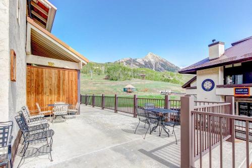 a patio with tables and chairs and a mountain at Slopeside Paradise at Axtel in Mount Crested Butte