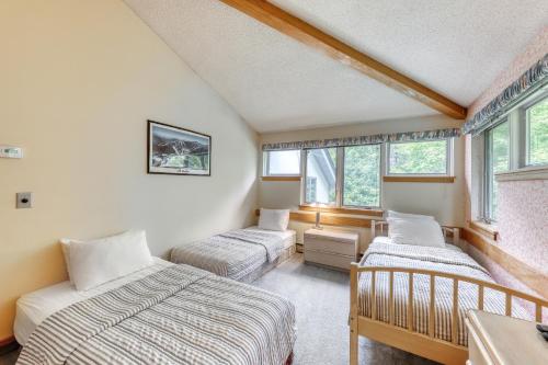 a bedroom with two beds and two windows at The Woods: Townhouse-F3 in Killington