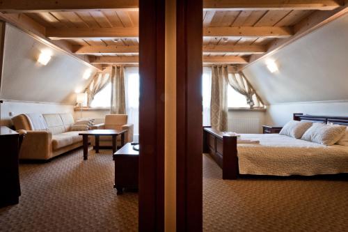 a bedroom with a bed and a couch in a room at Ośrodek Wypoczynkowy Marymont przy Dolinie Kościeliskiej in Kościelisko