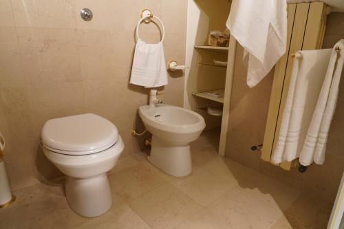 a white bathroom with a toilet and a sink at Rosita Luxury Apartments in Apricena