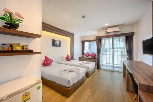 a hotel room with two beds and a television at Phuket Airport Place in Nai Yang Beach