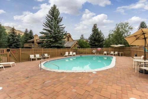 - une piscine avec des chaises et un parasol dans l'établissement Western Welcome, à Sun Valley