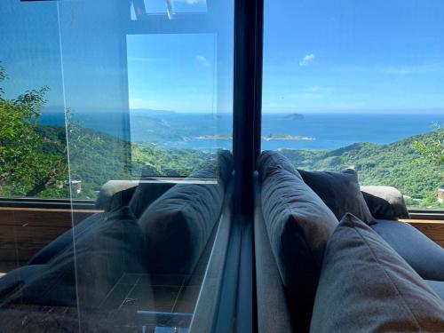 a couch in a room with a view of the ocean at Something Easy Inn in Jiufen