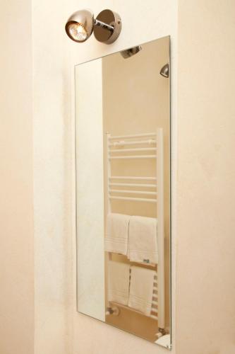 a mirror on a wall with towels in a bathroom at B&B Le Stanze del Duomo in Florence