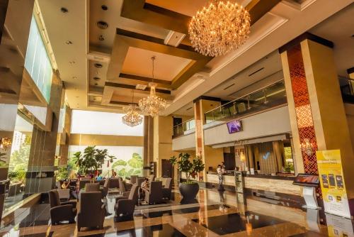 a lobby of a hotel with chairs and chandeliers at Kinta Riverfront Hotel & Suites in Ipoh
