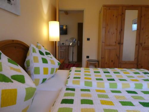 a bedroom with two beds with green and white sheets at Haus Daheim in St. Wolfgang