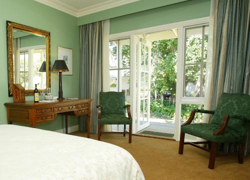 1 dormitorio con 1 cama, escritorio y sillas en Glen Isla House Bed & Breakfast Phillip Island, en Cowes