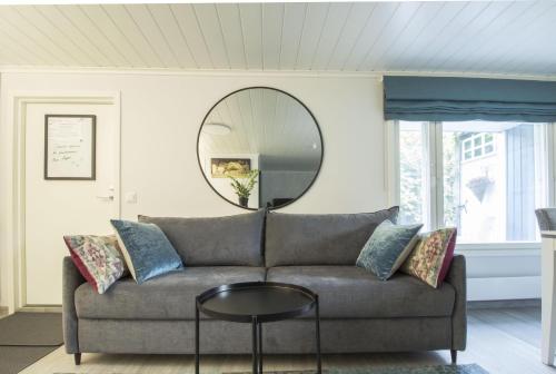 a living room with a couch and a round mirror at Airport Mint House Studio in Vantaa