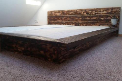 a large wooden bed sitting in a room at Kauzeri - home while away from home in Vildoga