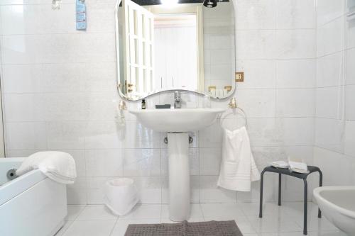 a white bathroom with a sink and a mirror at Rosita Luxury Apartments in Apricena
