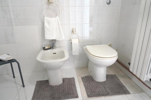 a white bathroom with a toilet and a sink at Rosita Luxury Apartments in Apricena