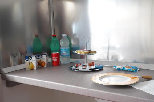 a counter top with a plate and soda bottles at Rosita Luxury Apartments in Apricena