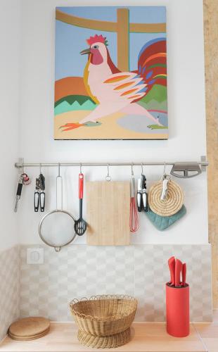 une cuisine avec une peinture d'un poulet sur le mur dans l'établissement Les chambres de l'ATELIER à Montignac Lascaux, à Montignac