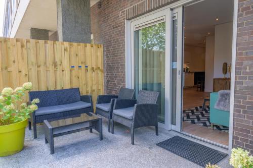 a patio with chairs and a table and a fence at Flonk Hotel Groningen Centre, BW Signature Collection in Groningen