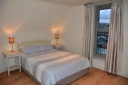 a bedroom with a bed and a large window at Apartment 3, Oakleigh House, Donnybrook Hill, Douglas Cork in Cork