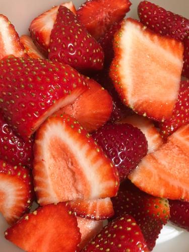 a pile of strawberries on a white plate at HARZ HOTEL und Gästehaus am Bornweg in Bad Sachsa