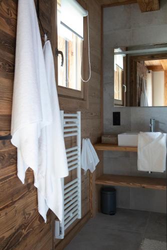 La salle de bains est pourvue d'une serviette blanche accrochée au mur. dans l'établissement B&B Boutique Chalet Nono, à Morzine