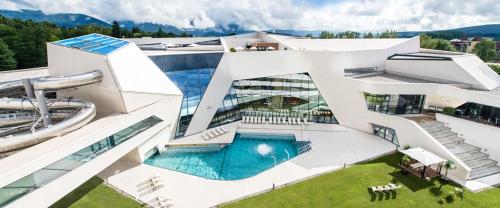 un grande edificio bianco con piscina di Appartement VIDMAR-FERIENGLÜCK ad Arriach