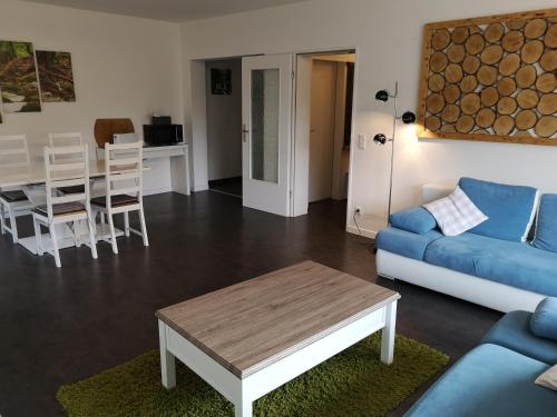 ein Wohnzimmer mit einem blauen Sofa und einem Tisch in der Unterkunft Hotel Clemens in Winterberg