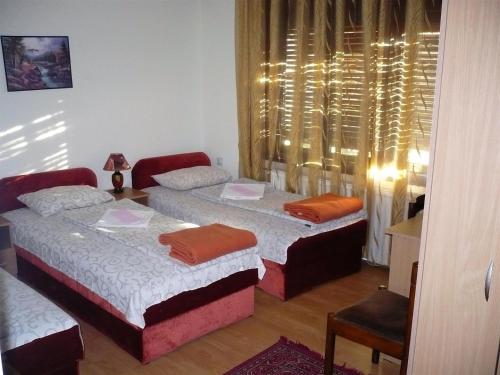 a bedroom with two beds and a window at Motel Stara Vrba in Kuršumlija