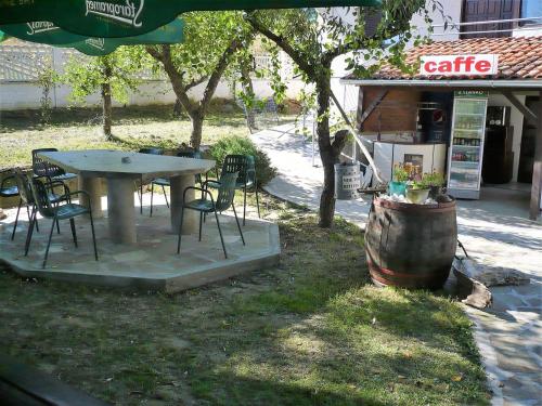 a picnic table and chairs next to a coffee shop at Motel Stara Vrba in Kuršumlija