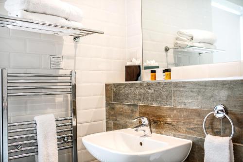 a bathroom with a sink and a bath tub at The Ainscow Hotel, BW Premier Collection in Manchester