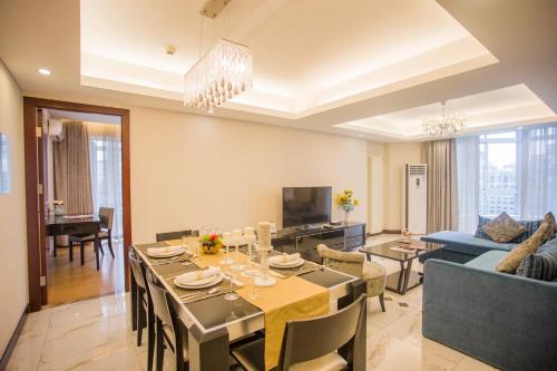 a dining room and living room with a dining table at Guangyao Service Apartment Beijing Ritan in Beijing