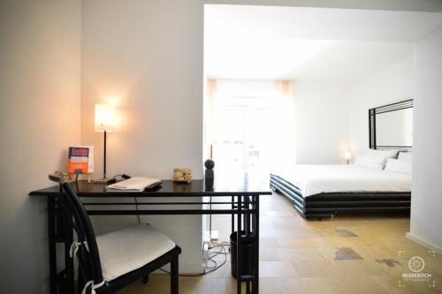 a bedroom with a desk with a bed and a phone at Domaine Leidinger in Saarbrücken