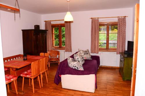 カルパチにあるPrzystanek Skocznia Apartamentyの紫色のソファとテーブル付きのリビングルーム