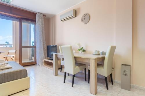 a living room with a dining room table and chairs at Residenze Su Planu in Cagliari