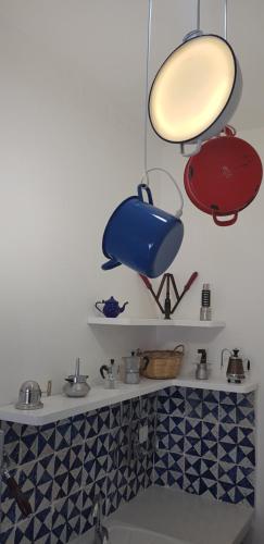 a shelf with some pots and pans on it at Da Giovanna a Marzamemi in Marzamemi