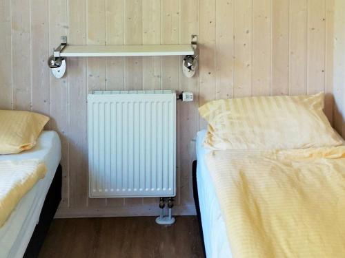 een kamer met 2 aparte bedden en een radiator bij Two-Bedroom Holiday home in Otterndorf 4 in Otterndorf