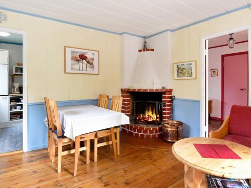 a dining room with a table and a fireplace at 8 person holiday home in S LEN in Lindvallen