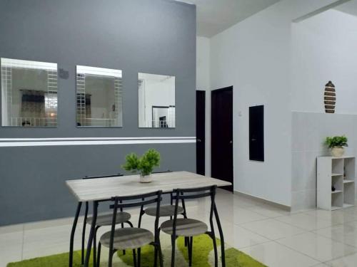 a dining room with a table and four chairs at Ana Homestay Ayer Keroh Melaka in Ayer Keroh