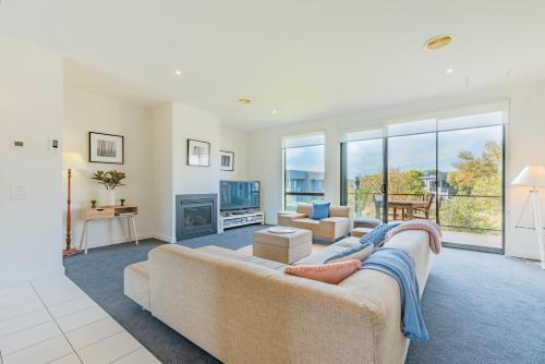 a living room with a couch and a fireplace at 3 Bedroom Townhouse - Pool and Tennis Court Access in Torquay