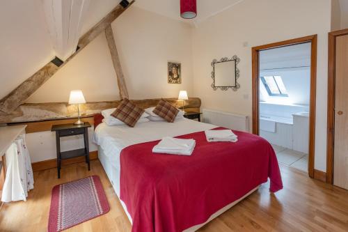 um quarto com uma cama grande e um cobertor vermelho em The Garlic Farm em Sandown