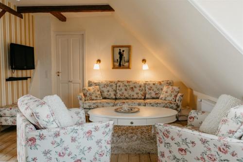 a living room with a couch and two chairs at Jungshoved Præstegård B&B in Præstø