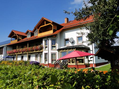 a large building with a red umbrella in front of it at Birkholmhof in Bärnau