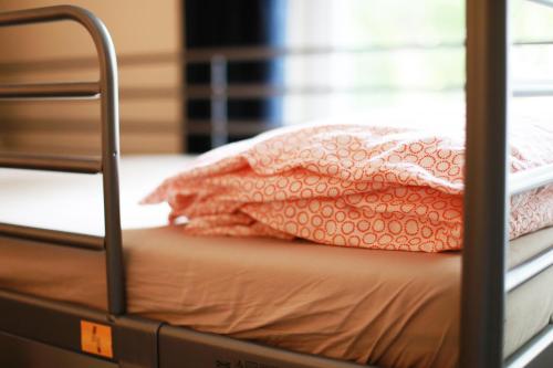 a bunk bed with a pink blanket on it at Hotelik Okęcie 39 - Nocleg i Parking Blisko Lotnisko Okęcie in Warsaw