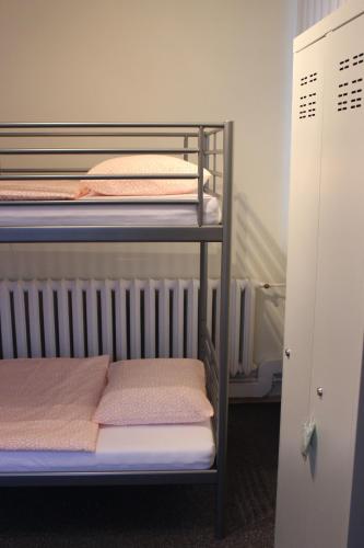 a bunk bed room with three bunk beds and a closet at Hotelik Okęcie 39 - Nocleg i Parking Blisko Lotnisko Okęcie in Warsaw