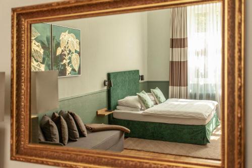 
a bedroom with a bed, mirror and a painting on the wall at Hotel Elba am Kurfürstendamm - Design Chambers in Berlin

