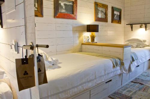 a bedroom with a white bed and a table at Surfers Lodge Peniche in Peniche
