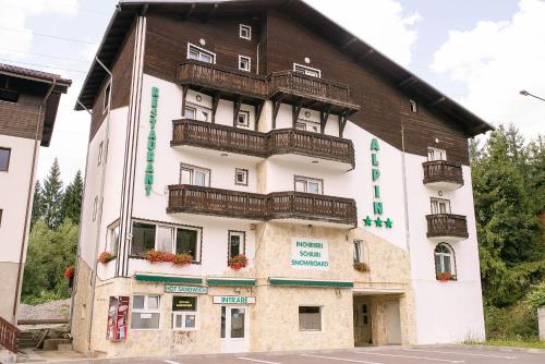 a building with balconies on the side of it at Pensiunea Alpin Predeal in Predeal