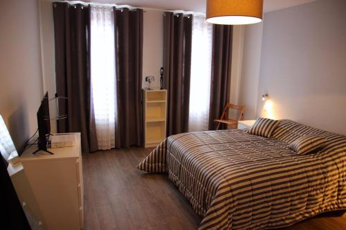 a bedroom with a bed and a television in it at Gîte Groseille in Ribeauvillé