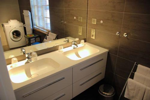 a bathroom with two sinks and a mirror at Gîte Groseille in Ribeauvillé