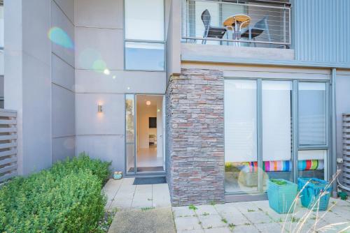 a building with a brick wall and a balcony at Stylish 3 Bedroom Townhouse - Free Parking in Torquay
