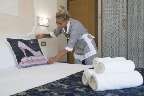 リッチョーネにあるRoyal Boutique Hotelのタオルを積んだ部屋の女性