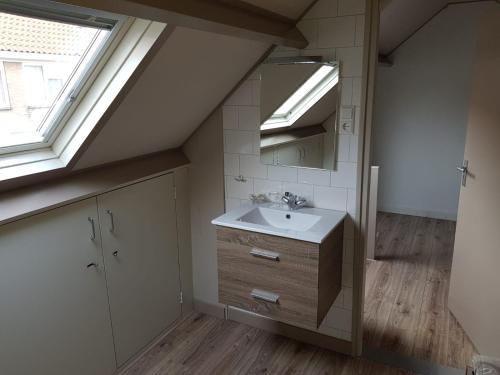 La salle de bains est pourvue d'un lavabo et d'un miroir. dans l'établissement Brugman, à Egmond aan Zee