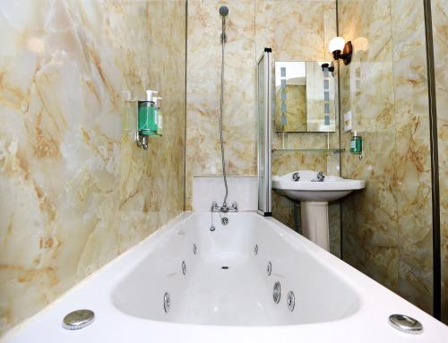 La salle de bains est pourvue d'une baignoire et d'un lavabo. dans l'établissement Ardlui Hotel, à Ardlui